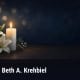 Fostoria News Memorial candle and lilies for Beth A. Krehbiel obituary.